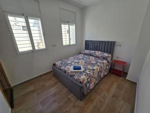 a bedroom with a bed and two windows at Villa Sabrina in Moulay Bousselham