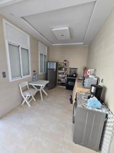 a living room with a table and a kitchen at Villa Sabrina in Moulay Bousselham