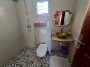 a bathroom with a toilet and a sink at Villa Sabrina in Moulay Bousselham +3 photos