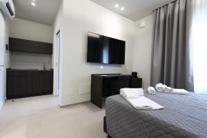 a bedroom with a bed and a flat screen tv at Rooms Residence Rubiera in Rubiera
