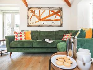 a green couch in a living room with a table at Shippon - Ukc9529 in Barnstaple