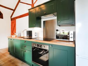 a kitchen with green cabinets and a stove at Shippon - Ukc9529 in Barnstaple