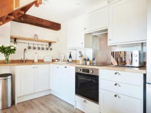 a kitchen with white cabinets and a black dishwasher at Willow - Ukc9530 in Barnstaple