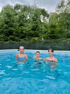 three women and a child swimming in a swimming pool at Hotel Restaurant Vizit in Truskavets