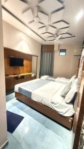 a bedroom with a bed and a tv on the ceiling at Hotel Planet villa in Ahmedabad