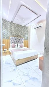 a bedroom with a large bed with pink pillows at Hotel Planet villa in Ahmedabad