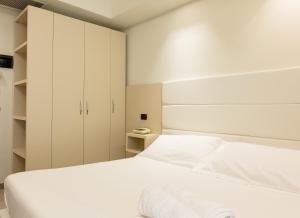a bedroom with a white bed and white cabinets at Hotel Twins in Vasto