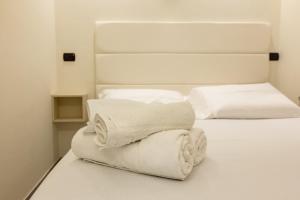 two white towels are stacked on a bed at Hotel Twins in Vasto +10 photos