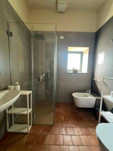 a bathroom with a shower and a tub and a sink at Puleera Boutique Hotel in Giarre