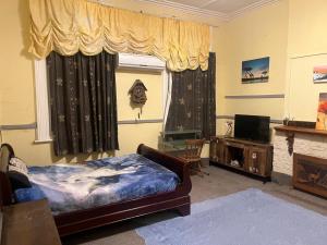 a bedroom with a bed and a window and a television at Sullivans backpackers in Waimate