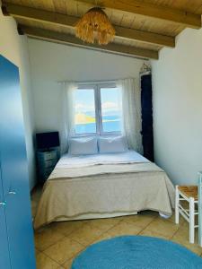 a bedroom with a large bed with a window at Myrto Signature Villa - Aegina in Aegina