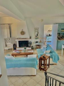 a living room with two couches and a fireplace at Myrto Signature Villa - Aegina in Aegina