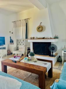 a living room with a coffee table and a fireplace at Myrto Signature Villa - Aegina in Aegina