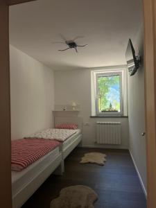 a small bedroom with a bed and a window at Apartma 35 in Soča +9 photos
