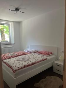 a bedroom with a bed with red and white pillows at Apartma 35 in Soča
