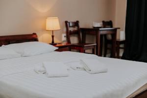 a white bed with two white pillows on it at Pensiune Restaurant ROUTE60 in Ciucea