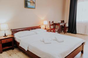 a bedroom with a bed with two towels on it at Pensiune Restaurant ROUTE60 in Ciucea
