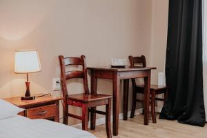 a desk with two chairs and a table with a lamp at Pensiune Restaurant ROUTE60 in Ciucea