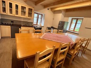 a large kitchen with a wooden table and chairs at Malga Valmaggiore in Bellamonte