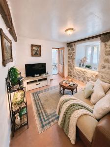 a living room with a couch and a tv at Stonehouse Kotor Bay in Kotor