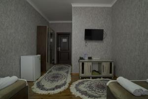 a living room with a couch and a tv on the wall at Hotel Ayyub Sultan in Urganch +9 photos