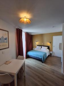 a hotel room with a bed and a table and a table sidx sidx at Appart 'Hôtel Le Mondes in Le Pouliguen