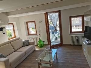 a living room with a couch and a glass table at Nancy House in Longarone