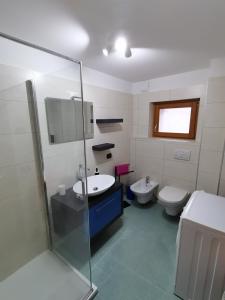 a bathroom with a sink and a toilet at Nancy House in Longarone +8 photos