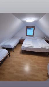 a attic room with two beds and a window at Green Sky House in Mostec