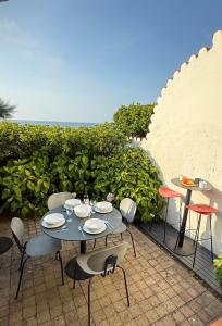 a table and chairs on a patio with the ocean at Maison de la mer in Hendaye