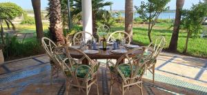 a wooden table with chairs and a table and a table and chairsktop at Le Refuge in Larache