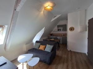 a living room with a blue couch and a staircase at Appart 'Hôtel Le Mondes in Le Pouliguen