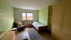 a bedroom with a bed and a chair and a window at Ferienwohnung Wolff, Kelkheim in Kelkheim