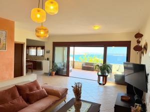 a living room with a couch and a view of the ocean at Bliss House Villa in Plaka