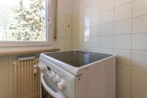a washing machine in a kitchen with a window at Casa Anna in Predazzo