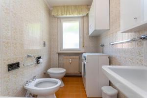 a small bathroom with a toilet and a sink at Casa Anna in Predazzo +24 photos