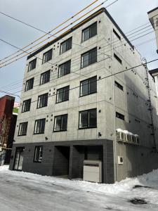 a large gray building with a lot of windows at エムズ千歳幸町2 in Chitose