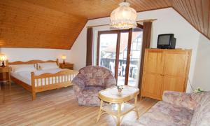 a bedroom with a bed and a couch and a table at Hotel Auf Dem Langenhof Wunstorf in Wunstorf