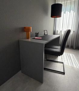 a desk with a chair and a lamp in a room at TheKarlchen in Rheda-Wiedenbrück
