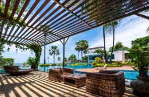 an outdoor patio with chairs and a swimming pool at The Palm Wongamat 22 in North Pattaya +38 photos