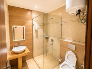 ein Badezimmer mit Dusche, Toilette und Waschbecken in der Unterkunft Hotel Supreme Regency in Ludhiana