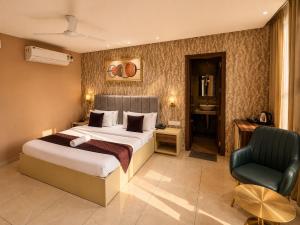 ein Hotelzimmer mit einem Bett und einem Stuhl in der Unterkunft Hotel Supreme Regency in Ludhiana