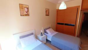 a bedroom with two beds and a closet at Reco flores PALM in Ben Slimane