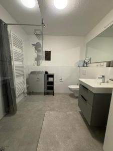 a white bathroom with a toilet and a sink at TheKarlchen in Rheda-Wiedenbrück +3 photos
