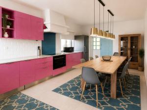 a kitchen with pink cabinets and a wooden table at Casa Concha - Peaceful and Relaxing in Lagos