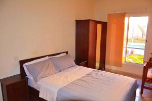 a bedroom with a bed with a wooden headboard and a window at Reco flores PALM in Ben Slimane