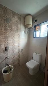 a bathroom with a toilet and a window at Elysian Villa by Hostel Jerusalem in Kodaikānāl