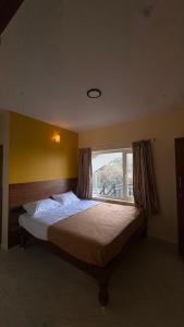 a bedroom with a large bed with a window at Elysian Villa by Hostel Jerusalem in Kodaikānāl +30 photos