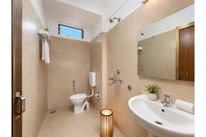 a bathroom with a sink and a toilet and a mirror at Hotel Sairaj inn - Restaurant - Free Wi-Fi - Premium Rooms - Balcony - Parking in Puri
