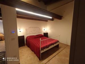 a bedroom with a bed with a red comforter at La Scienza Nuova in Vatolla